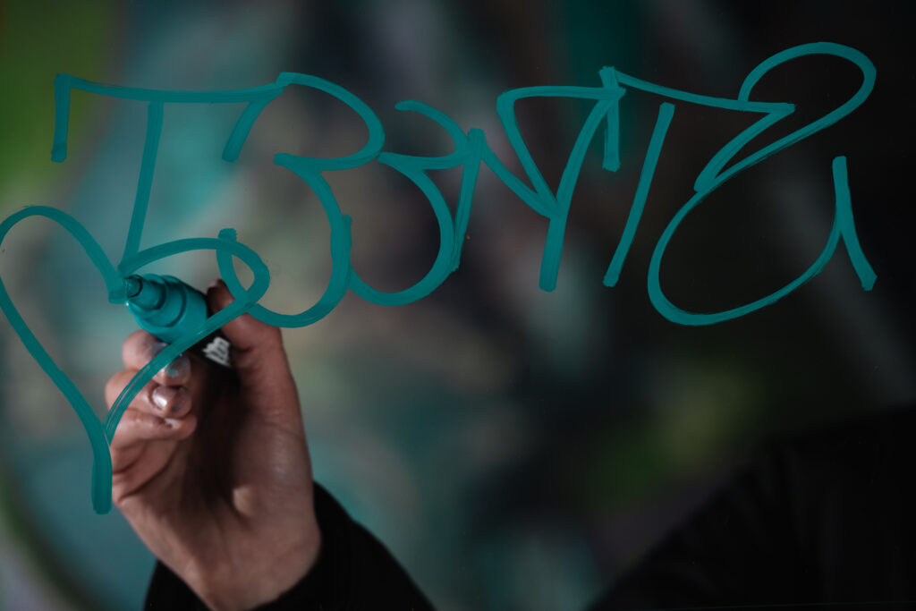 cropped view of man writing graffiti with marker