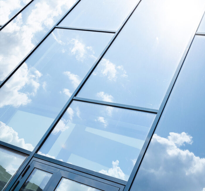 Glass building facade with blue sky reflection